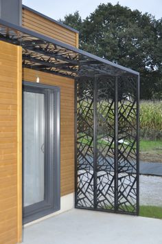 a wooden building with an open door on the outside and grass in the back ground