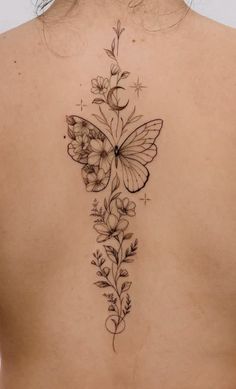 a woman's back with flowers and butterflies on it