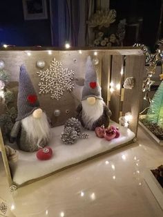 two gnomes are sitting in front of a christmas display