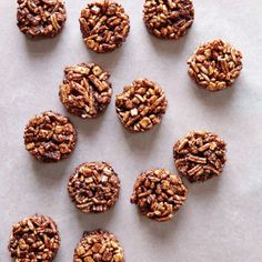 several cookies are arranged on a sheet of wax paper with pecans in the middle