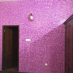 a room with purple wallpaper and wooden doors