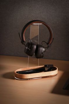 a pair of headphones sitting on top of a wooden stand