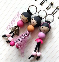 some little dolls are sitting on top of a piece of paper with keys attached to them