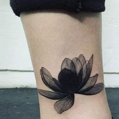 a woman's foot with a black flower tattoo on the left side of her leg