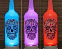 three different colored bottles with skulls on them