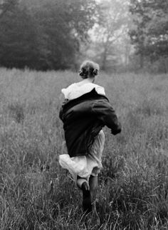 black and white photograph of woman running through field