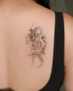 the back of a woman's shoulder with a tattoo on it