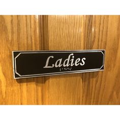 a sign that says ladies on it is hanging on the door