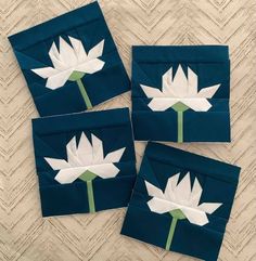 four pieces of paper with white flowers on them