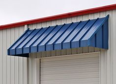 an open garage door with a blue awning