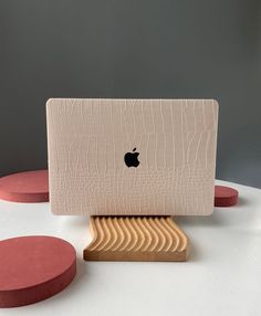 an apple computer sitting on top of a wooden stand