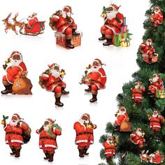 santa claus figurines are posed next to a christmas tree with presents on it