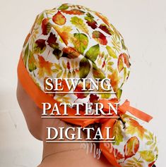 the back of a woman's head wearing an orange and white hat with leaves on it