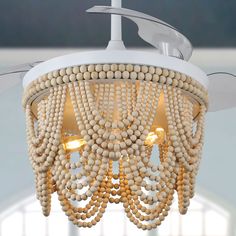 a chandelier made out of wooden beads hanging from a ceiling fixture in a room