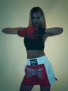 a woman with boxing gloves on posing for the camera