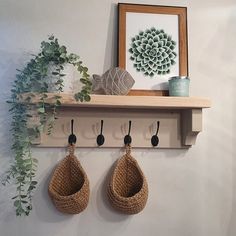 there are two hooks on the wall with some plants hanging from it's hooks