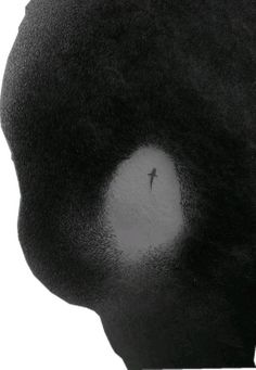 a black and white photo of a person's head with a small figure in the center