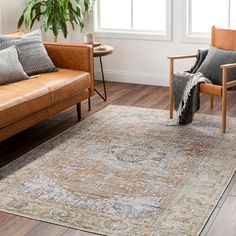 a living room with two couches, a chair and a rug on the floor