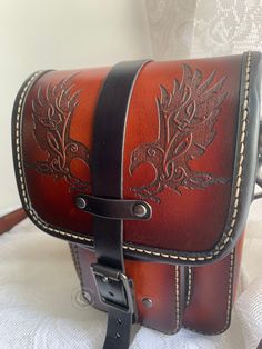 This Product is as Photographed, meaning the pictures you see is what you get! Completely unique and can never be replicated   Want a bag that can go on your hip and your shoulder? Look no further! This beautiful leather bag features images of Odin's Ravens and has interchangeable straps. You can use the shoulder strap as a cross body for easy access and security or use the loop straps to add it to your belt for handsfree use! This bag has a main compartment with plenty of space for your everyda Daily Use Satchel Shoulder Bag With Case Included, Rectangular Belt Bag With Leather Lining For Travel, Rectangular Leather Lining Belt Bag For Travel, Leather-backed Satchel Bag As Gift, Leather Backed Satchel Bag As A Gift, Leather Camera Bag With Mobile Phone Pouch, Handmade Saddle Shoulder Bag For Travel, Rectangular Leather Saddle Bag With Mobile Phone Bag, Daily Use Saddle Bag With Leather Backing