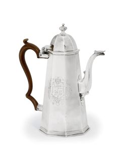 a silver coffee pot with a wooden handle on the front and sides, in an ornate design