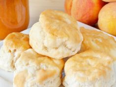 some biscuits are on a white plate next to peaches