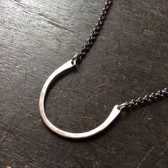 This simple necklace resembles a horse shoe and serves as a ring holder. Hammered sterling is united by oxidized sterling chain. Great on it's on or with long layers.(RING IN 2ND PHOTO NOT INCLUDED)1" wide, 16" sterling chain Minimalist Hand Forged Oval Jewelry, Everyday Sterling Silver Hoop Necklaces, Minimalist Silver Hoop Necklace, Everyday Silver Hoop Necklaces, Hand Forged Open Circle Jewelry As Gift, Hand Forged Open Circle Jewelry For Gift, Hand Forged Open Circle Jewelry Gift, Simple Hand Forged Jewelry As Gift, Simple Hand Forged Sterling Silver Jewelry