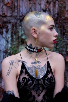 a woman with tattoos and piercings on her head