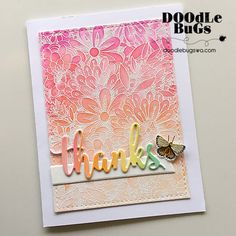 a close up of a thank you card with a butterfly on the front and flowers in the back