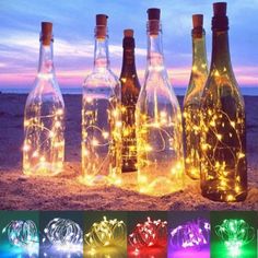 bottles with lights in them sitting on the sand at night and one has a message that reads uk stock