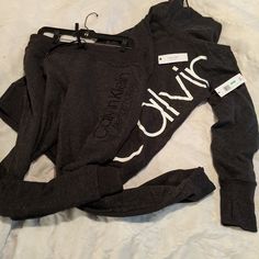 Nwt Calvin Klein Set. Fleece Comfy Set With Horizontal Logos On Both Top And Bottom. Ribbed Cuffs On Both Pants & Hoodie. Logo Covers The Bottom Back Side Of The Hoodie. Hoodie Has Kangaroo Pocket For Keeping Your Hands Warm. Also It Has A Slouchy Neck That Encloses Once Drawstrings Are Pulled. Drawstrings On Both Hoodie And Pants. Popular Calvin Klein Logo On Ends Of Drawings. Color: Charcoal Gray Fitted Calvin Klein Athleisure Tops, Calvin Klein Fitted Top For Loungewear, Calvin Klein Set, Calvin Klein Sport, Hoodie And Pants, Mock Neck Sweatshirt, Cowl Neck Sweatshirt, Hoodie Logo, Half Zip Pullover