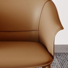 a brown leather chair sitting on top of a carpeted floor