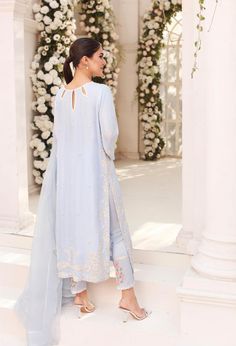 An enchanting three piece design on ice blue raw silk with intricate embroidery details alongside clusters of hand sewn pearls. Paired with a frilly dupatta and embroidered trousers for elegance unmatched. Order Duration: 4 to 6 weeks Blue Chinon Lawn Suit For Festive Occasions, Festive Blue Chinon Lawn Suit, Unstitched Light Blue Lawn Suit For Wedding, Blue Lawn Suit With Dabka Work For Reception, Bollywood Style Blue Lawn Suit With Mirror Work, Blue Semi-stitched Lawn Suit For Reception, Blue Lawn Suit For Reception On Eid, Elegant Blue Raw Silk Lawn Suit, Elegant Blue Chinon Lawn Suit