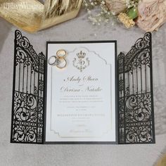 the wedding stationery is laid out with gold and black accents, such as rings