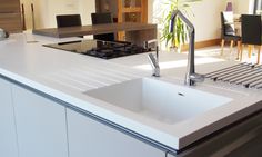 a kitchen with a sink, stove and dining room table in the backround