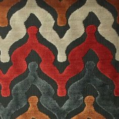 an area rug with different colors and designs on the ground, including black, red, gray, orange, and white