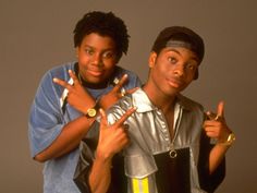 two young men posing for the camera with their fingers in the shape of peace signs