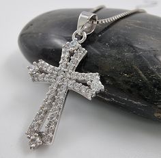 💖 Design: This beautiful Cross pendant is made from 925 Sterling Silver and adorned with sparkling Cubic Zirconia Crystal. 💖 This Catholic cross is intended to give a protection, bringing healing and positive transformation to the wearer. 💖 Authentic handcrafted piece provided directly from the Holy Land, Jerusalem. Handmade with the finest attention to detail. Blessed in the Holy Sepulcher Church. 💖 Size: Pendant: 2.5 cm (1 inch). Weight: approximately 1.8 gr This amazing pendant has protective qualities and spiritual benefits. 💖 Ideal Gift: This beautiful cross pendant comes with an elegant gift pouch and certificate of authenticity. 18 Inch Silver Box Chain Included. A perfect gift for women, men, friend, and so on. Can be used in birthday, wedding, Holidays gift, anniversary, or o Cross Necklace With Pave Setting For Gift, Cross Necklace With Pave Setting As Gift, Pave Setting Cross Necklace For Gift, Silver Cross Jewelry With Brilliant Cut, Sterling Silver Cross Pendant With Pave Setting, Sterling Silver Pave Setting Cross Pendant Jewelry, Silver Cross Necklace With Brilliant Cut, Silver Cubic Zirconia Cross Pendant Necklaces, Silver Cross Pendant With Pave Setting