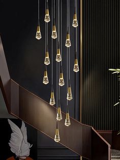 a bunch of lights that are hanging from a stair rail in a room with black walls