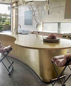 a modern kitchen with an island counter and two chairs in front of the countertop