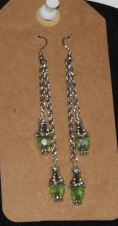 3" silver chain dangle earings with green crystal dangles Green Dangling Charms Jewelry, Green Dangle Jewelry With Dangling Charms, Green Dangle Jewelry With Charms, Green Dangle Crystal Earrings, Dangle Earrings With May Birthstone In Metal, May Birthstone Dangle Earrings, Green Drop Earrings With Dangling Charms, Green Crystal Earrings For Jewelry Making, Green Nickel Free Dangle Chandelier Earrings