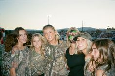 a group of women standing next to each other in front of a crowd at a sporting event