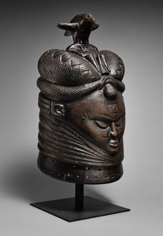 an old bronze head with a bird on top