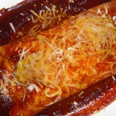 an enchilada covered in cheese and sauce