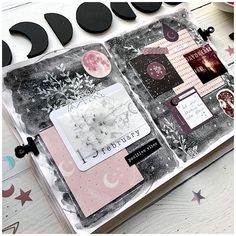 an open scrapbook with black and white images on it, surrounded by stars and moon shapes