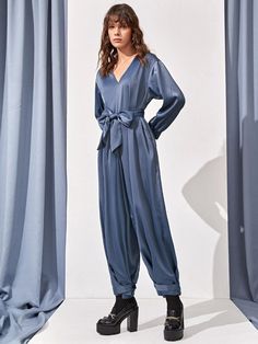 Step out in style with our Hidden Pocket Knot Hem Belted Jumpsuit. This elegant jumpsuit features a high waistline, wide leg, and drop shoulder sleeves for a comfortable fit. The V-neckline and belted waist add a touch of sophistication, while the hidden pockets offer a convenient place to store your essentials. The knot hem and zipper details complete the look, making it perfect for any occasion. Made from non-stretch fabric with a blend of polyester and elastane, it is both durable and comfortable. Machine wash or dry clean for easy care. Make a statement with this plain pattern jumpsuit, exclusively available at Comfy Jumpsuits. Specifications: Style: Elegant Pattern Type: Plain Type: Wide Leg Details: Belted, Knot, Pocket, Zipper Length: Long Fit Type: Regular Fit Neckline: V neck Slee Belt Jumpsuit, Comfy Jumpsuits, Jumpsuit Elegant, Jumpsuit Pattern, Zipper Detail, Shoulder Sleeve, Drop Shoulder, Stretch Fabric, Wide Leg