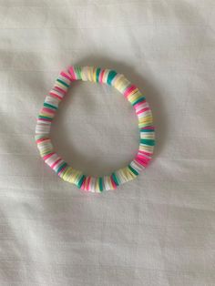 a bracelet with multicolored beads on a white surface, in the shape of a circle