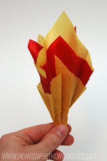 a hand holding up a red and yellow origami flower