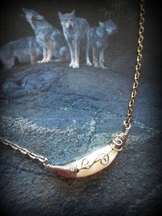 three wolf necklaces sitting on top of a rock