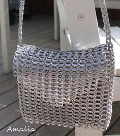 a silver purse sitting on top of a white chair