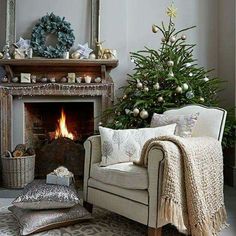 a living room filled with furniture and a christmas tree in front of a fire place